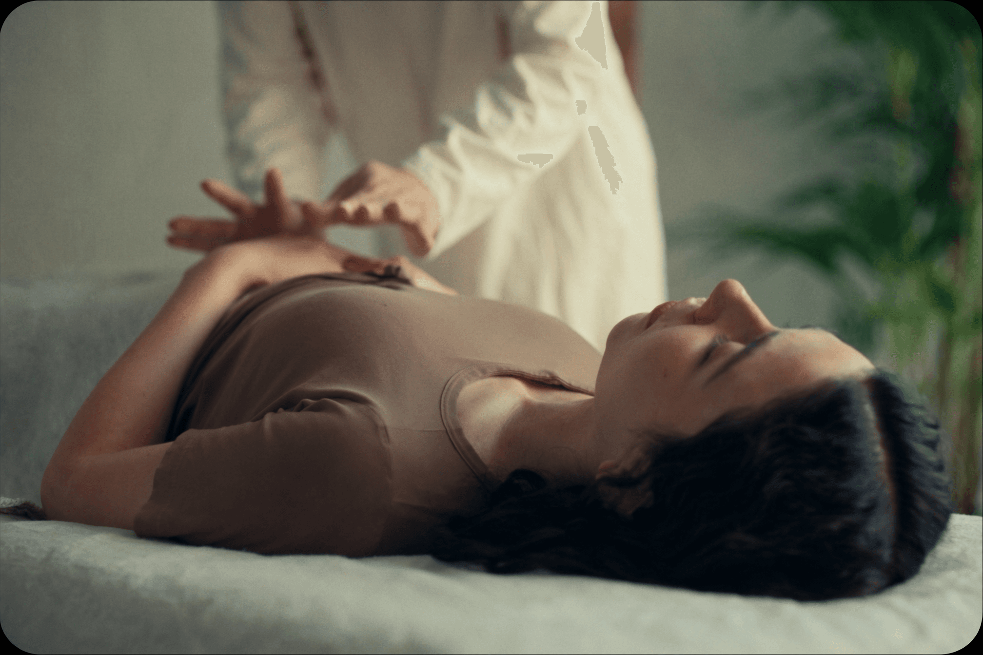 Practitioner's hands resting gently above a relaxed client during a calm reiki treatment session.